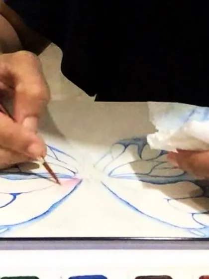 A close-up of a student working on delicate butterfly wings with watercolors. Our classes focus on building skills step-by-step, so you can tackle detailed projects with confidence.