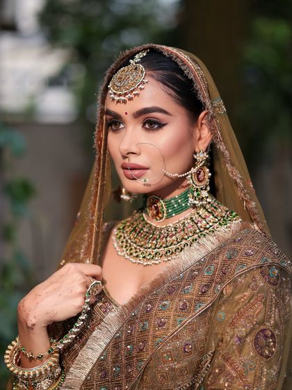 A side profile showcasing the intricate details of the bridal look, from the perfectly placed bindi to the flawless contouring.