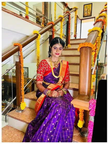 This pose captures the elegance of the bride's attire and the festive decorations. Her makeup is kept timeless to match the traditional feel.