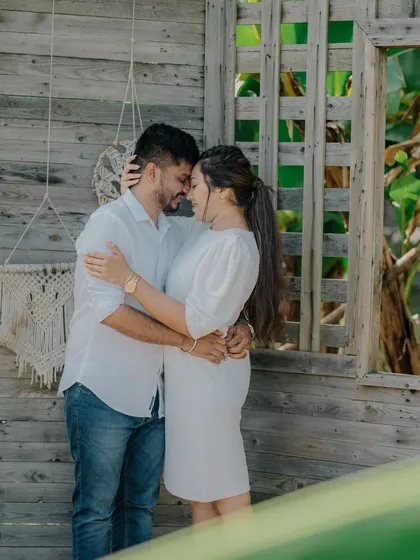 An intimate and loving embrace. The natural wood and green leaves in the background create a beautiful, organic setting for this romantic portrait.