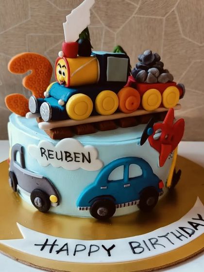 A colorful cake for a toddler who loves trains and cars. This design features a fondant train on top and cute cars around the side.