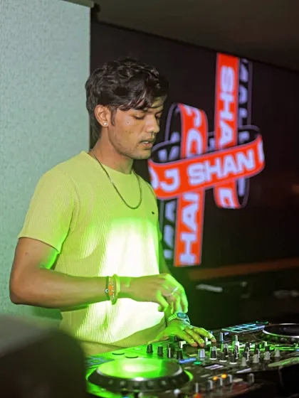 Behind the decks, creating magic with every beat. My logo is on the screen, and I'm focused on the mix.