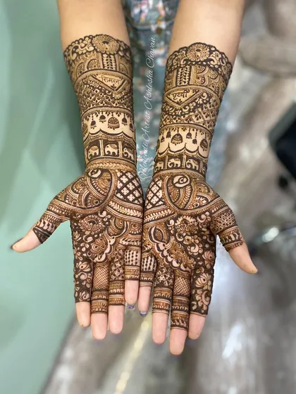 A traditional Indian mehendi design with elephant motifs. The patterns are intricate and cover the hands and arms in a classic, beautiful style.