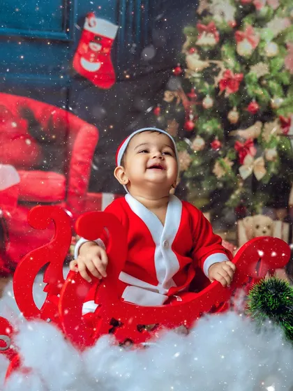 The magic of Christmas. This little Santa is having a wonderful time in his sleigh, surrounded by snow and festive decorations.