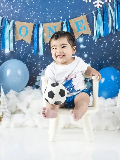 A winter wonderland cake smash session for a one-year-old boy, complete with a soccer ball for our little sportsman.