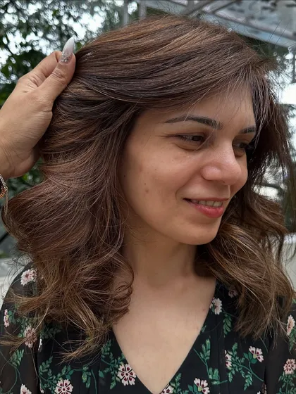This client flew in from Dubai for my signature 'Caramello' color. I blended caramel highlights into her hair and covered her greys for a fresh, youthful look. The final style with soft waves really shows off the dimension.