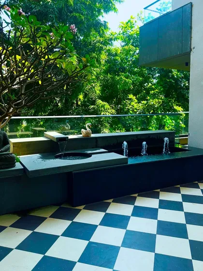 Even a small balcony can become a peaceful retreat. For this Swami Nagar home, I designed a custom water feature with the soothing sound of flowing water, a serene Buddha statue, and a frangipani tree, transforming the space into a personal sanctuary.