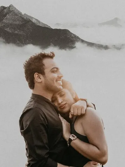 Above a sea of clouds on a misty mountain, this couple's embrace feels like the only thing in the world. This black and white portrait focuses purely on the serene, powerful emotion of their bond during their outdoor couple photoshoot.