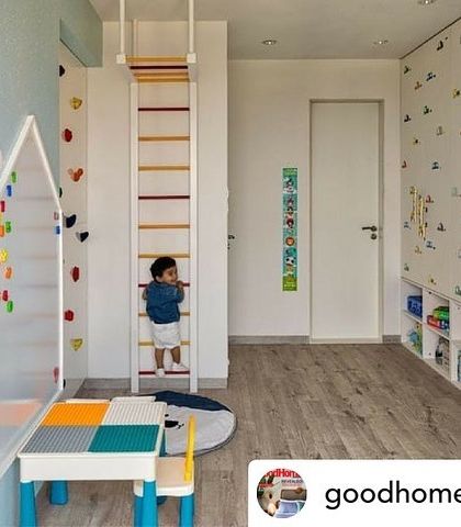 As featured in Good Homes Magazine, this kids' room is designed for play and adventure. It includes a climbing ladder, a rock-climbing wall, and low-level storage bins for easy access to toys.