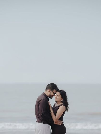 A quiet and intimate embrace against a minimalist sea backdrop. This simple composition puts all the focus on the couple's connection.