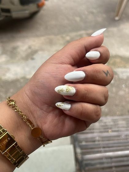 A chic and simple design on natural nails. A crisp white polish with a single accent nail featuring gold foil.