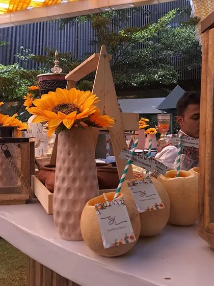 Integrating the sunflower theme with refreshing welcome drinks, serving custom-tagged beverages in hollowed-out melons.