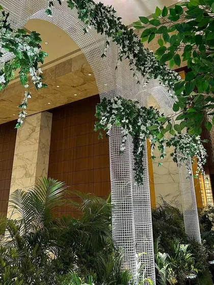 A detail of the entrance archway, where modern white lattice is adorned with cascading green and white wisteria. This creates a feeling of walking through a magical, contemporary garden.
