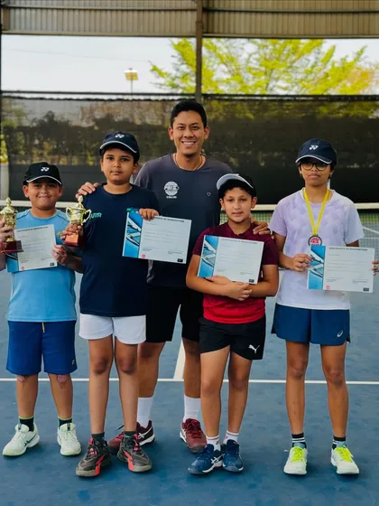 Nurturing the next generation of champions. Our head coach celebrates with the young position holders from our PBI 50th Anniversary UTR tournament, fostering a supportive and encouraging environment from the very beginning.