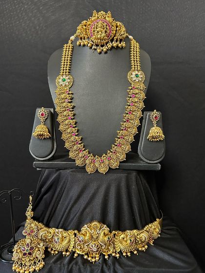 A beautiful antique finish bridal set with a kasumalai necklace and a temple choker. The set is complete with a matching vaddanam and jhumkas.