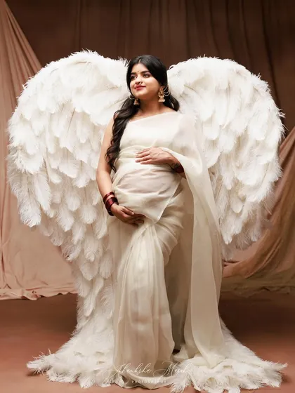 A fusion of the divine and the traditional. Combining ethereal angel wings with the grace of a saree, we create a powerful portrait of the guardian angel a mother is to her child.