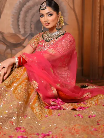 The bride seated amidst a bed of rose petals, looking like a true queen. The full lehenga is on display, and her makeup remains the focal point of her regal look.