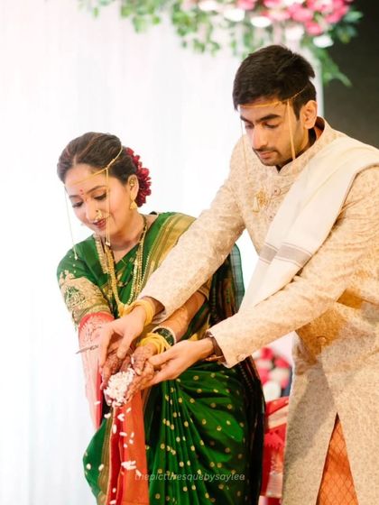 The bride and groom performing the 'Laja Homa' ritual together, a significant and beautiful part of the Maharashtrian wedding ceremony.