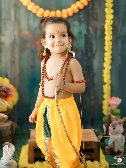 A sweet, smiling portrait of the 'Little Ram'. The child's gentle expression and traditional attire make this an incredibly endearing cultural photograph.