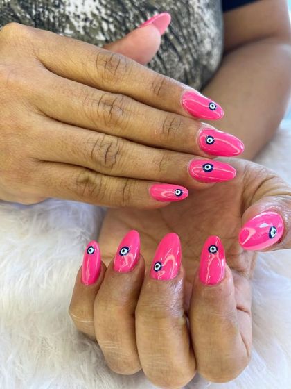 A bold and playful design featuring the protective evil eye symbol. The bright pink base makes the hand-painted eyes pop, creating a fun and eye-catching manicure.