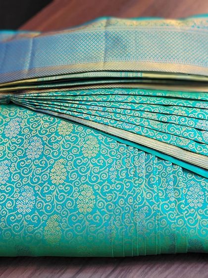 The back view of the folded turquoise saree.