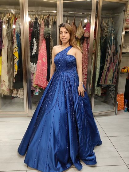 A one-shoulder royal blue satin gown with scattered embellishments. This is a perfect choice for someone who wants a modern, elegant, and comfortable outfit.