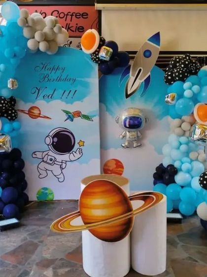 An out-of-this-world space theme for a 6th birthday. We designed a complete astronaut adventure with custom backdrops, planet cutouts, a rocket ship, and a balloon arch that looks like a galaxy.