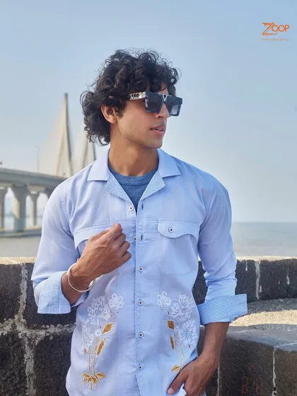 This light blue casual shirt with delicate white and gold embroidery is a perfect example of our sophisticated casual wear, seen here against the backdrop of the Mumbai sea link.