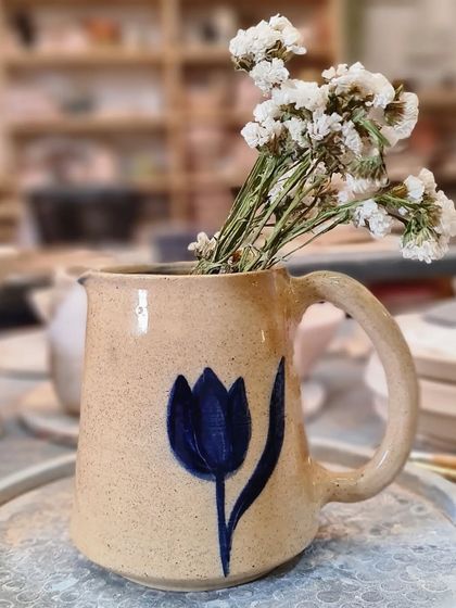 This beautiful jug with a hand-painted blue tulip is not only a useful addition to your kitchen but also a gorgeous piece to add to your table decor. It is currently available.
