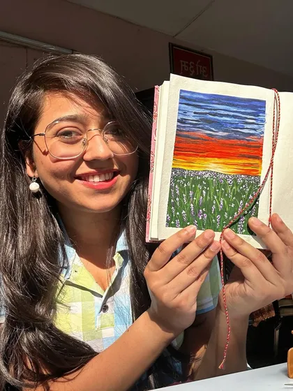 Here I am, happily holding one of my sunset paintings from my sketchbook series. Painting sunsets is my absolute favorite.