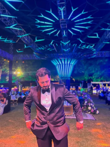 A candid shot under the magnificent blue lighting of a Sangeet venue. The ambiance is just as important as the performance.