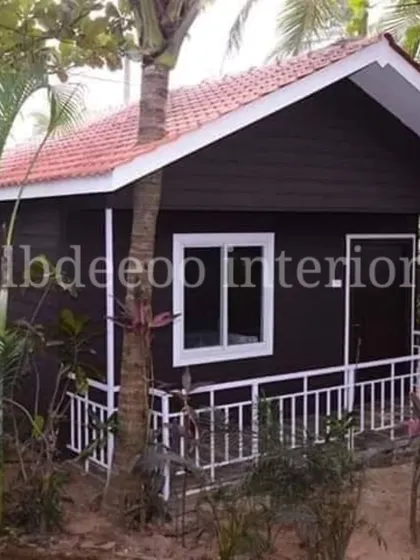 A classic prefab villa with a tiled roof and a small porch, perfect for a farmhouse setting. The design is simple, elegant, and blends well with the surrounding greenery.