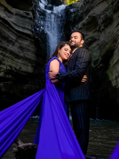 A romantic embrace by a waterfall, made even more magical by our royal blue trail gown. The flowing fabric adds a beautiful sense of motion and color to the scene.