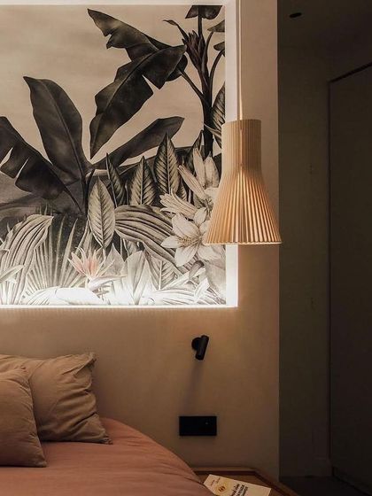 A Secto pendant light used as a bedside lamp, its warm, downward-focused light creating a relaxing atmosphere while complementing the natural textures of the room.