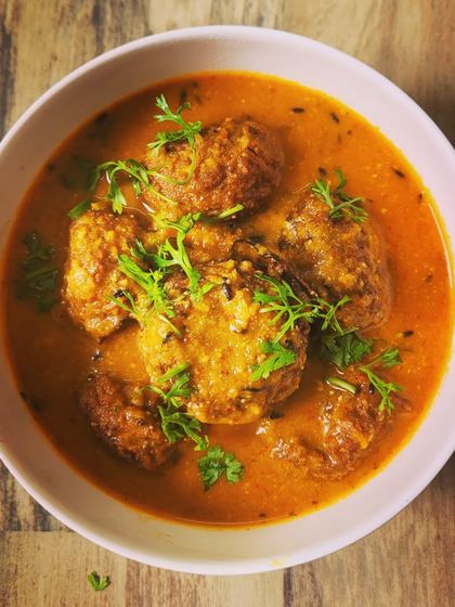 My Lauki Kofta curry is a delicious vegetarian option. Soft dumplings made from bottle gourd are simmered in a smooth, savory tomato and onion gravy, garnished with fresh coriander.