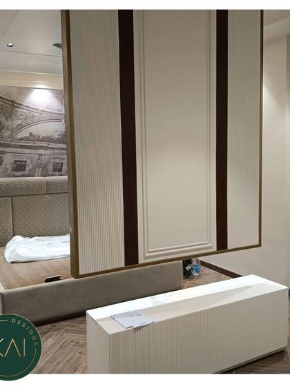 This bedroom features a custom bed with a quilted headboard, paired with a unique, suspended TV panel. This innovative design solution saves space and adds a futuristic, high-end touch to the room.