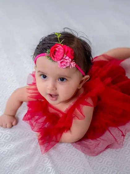 This little lady in red is all set for her "halfway to one" photoshoot, showing off her tummy time skills.