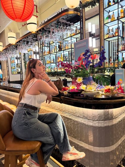 Posing at the bar in my casual-chic outfit. This shows how a simple look can be elevated with the right attitude and setting.