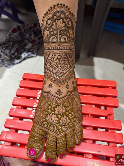 A full-coverage bridal foot mehendi with intricate details. This design features lotuses, paisleys, and dense grid work for a rich and traditional look.