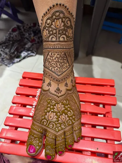 A full-coverage bridal foot mehendi with intricate details. This design features lotuses, paisleys, and dense grid work for a rich and traditional look.