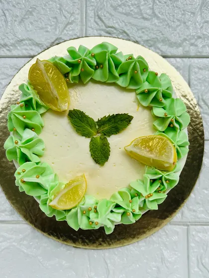 A top-down view of our Mojito Cake, showing the fresh mint and lemon garnish. It's the perfect light and zesty dessert for a summer party.