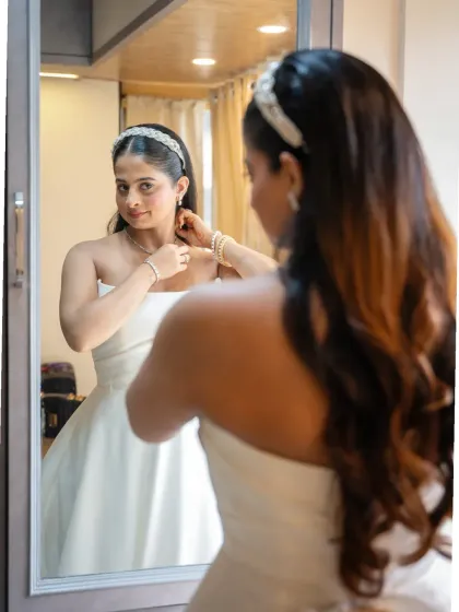 A sweet getting-ready shot of the bride. Capturing these final moments of preparation in the mirror is a beautiful way to tell the story of the day.
