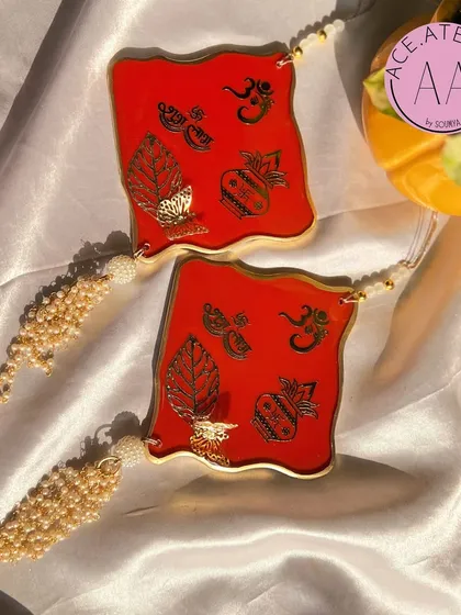 A vibrant red set of Shubh Labh hangings, featuring traditional kalash and leaf motifs. The gold detailing on the red resin makes these pieces truly stand out.