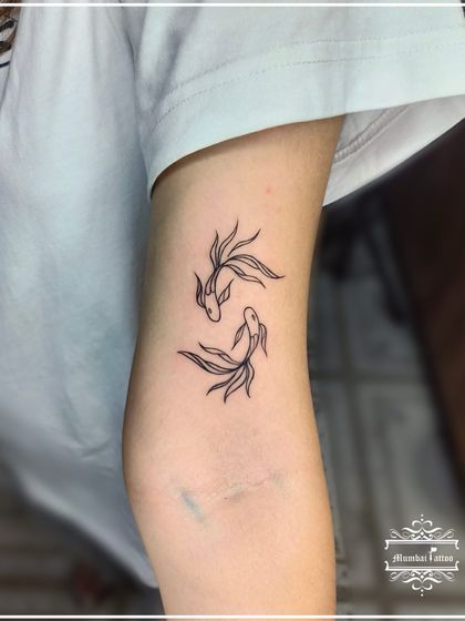 A pair of Pisces fish in a fine line style. We often create custom zodiac tattoos that reflect the personality of the sign, like these gracefully swimming fish.
