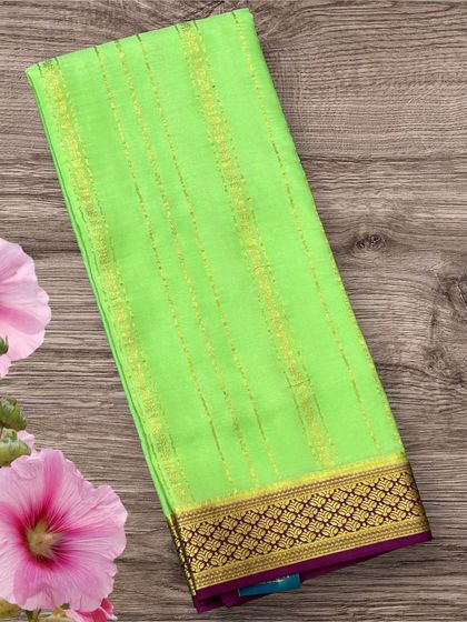 A fresh neon green pure crepe Mysore silk saree with delicate gold stripes and a deep purple contrast border.
