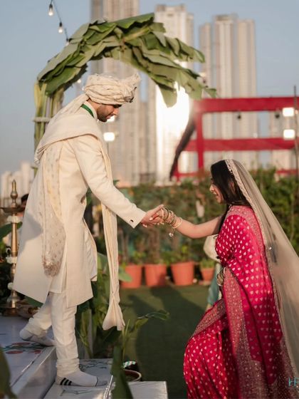 The groom helps his bride onto the stage, a simple gesture of support and partnership that marks the beginning of their new journey together.