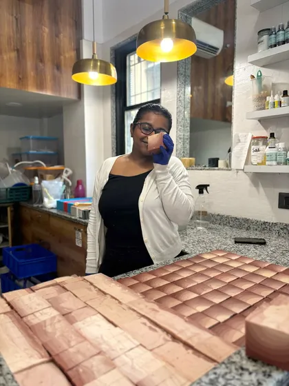 A happy moment in the studio, holding up a freshly cut bar of soap. The passion for what we do is poured into every single product.