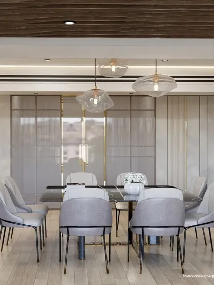 This view highlights the fluted glass and gold-trimmed partitions behind the dining set. These elements add a layer of texture and privacy while contributing to the room's overall elegant and high-end feel.