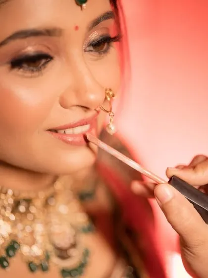 A behind-the-scenes moment, applying the final touch of lipstick to complete the bridal look.
