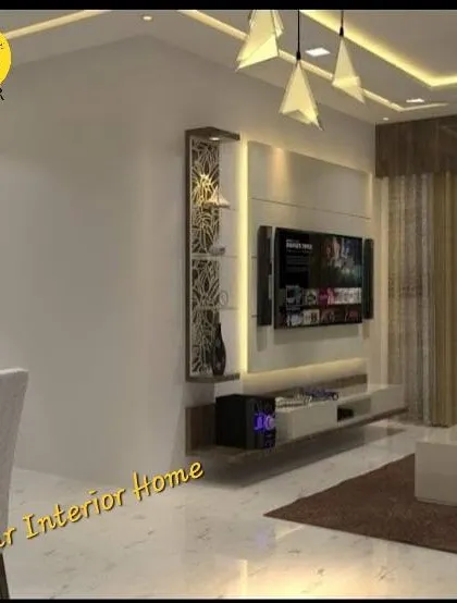 A view of the TV unit and a partial look at the living area. The floating console and vertical display cabinet with jali work are custom-made to fit the space perfectly.